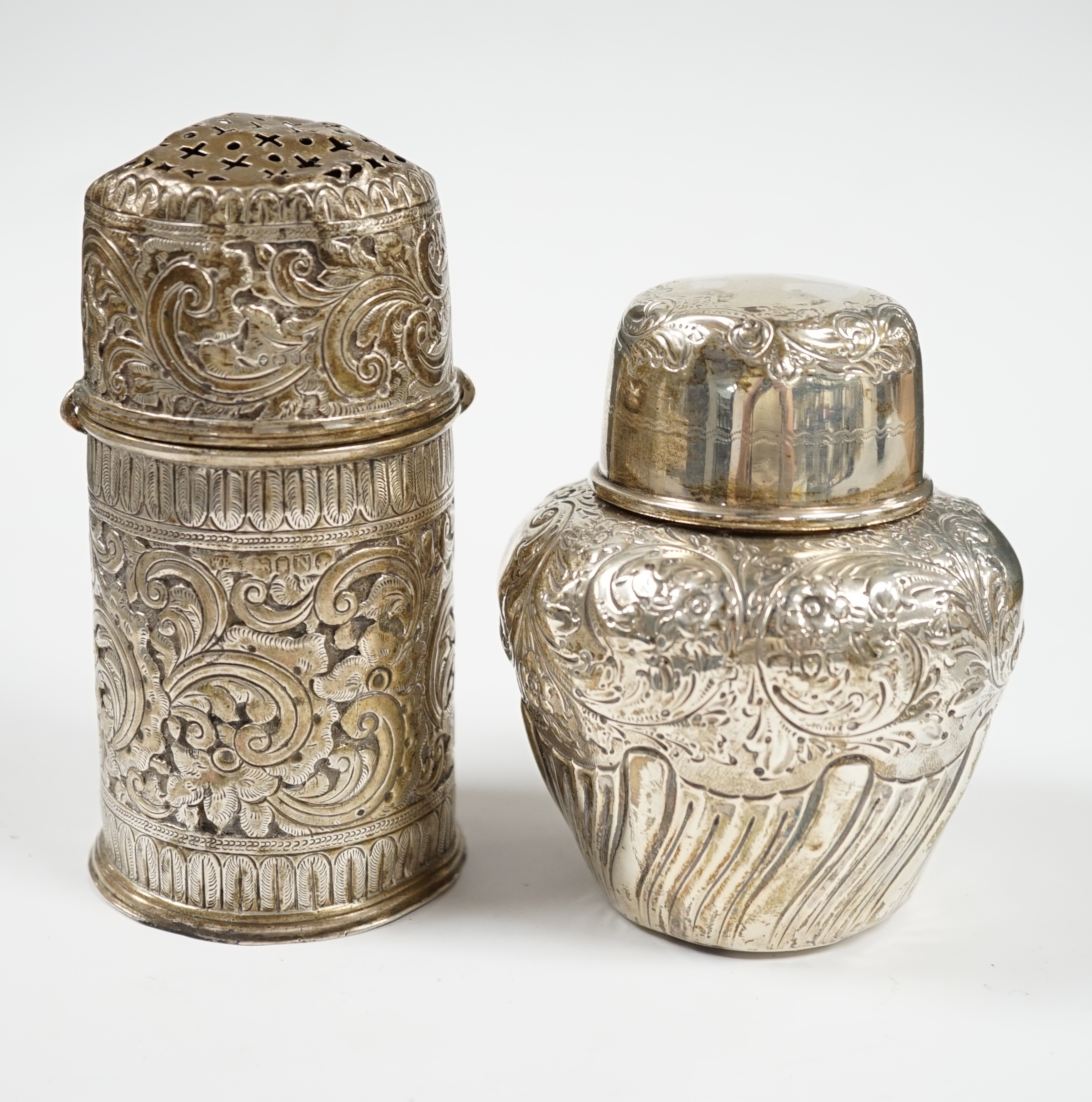 A late Victorian repousse demi-fluted wrythened silver tea caddy and cover, W & C Sissons, London, 1895, 10.3cm, together with a similar repousse silver lighthouse sugar caster, London, 1888, 10oz. Condition - poor